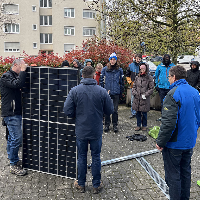 People around a solar panel