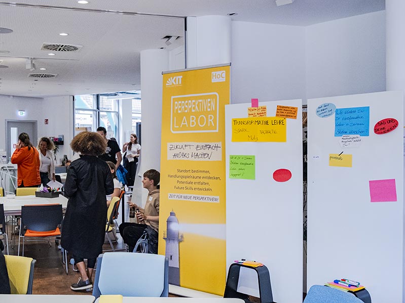 Das Bild zeigt Poster und Whiteboards, die sich mit dem Perspektivenlabor des KIT House of Competence (HoC) und der Transformativen Lehre beschäftigen.