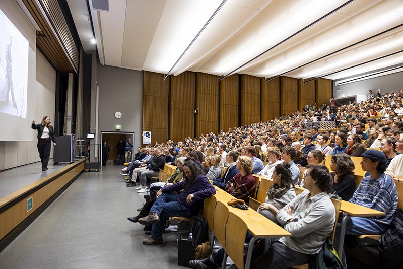Person hält Vortrag in einem Hörsaal.