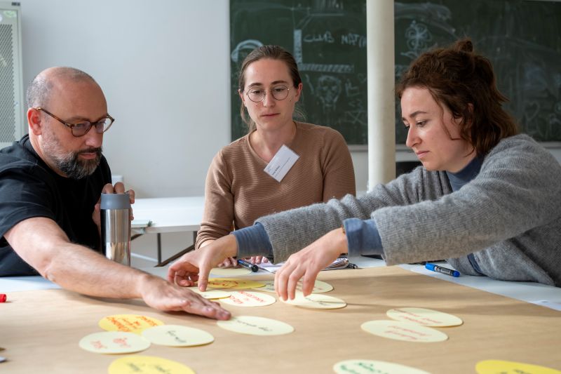 Gruppe bearbeitet Worskhop-Material am Tisch.