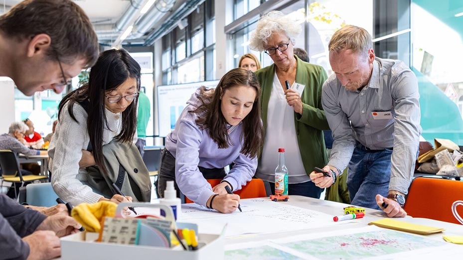 Menschen bei einem Workshop schreiben an einem Tisch. 