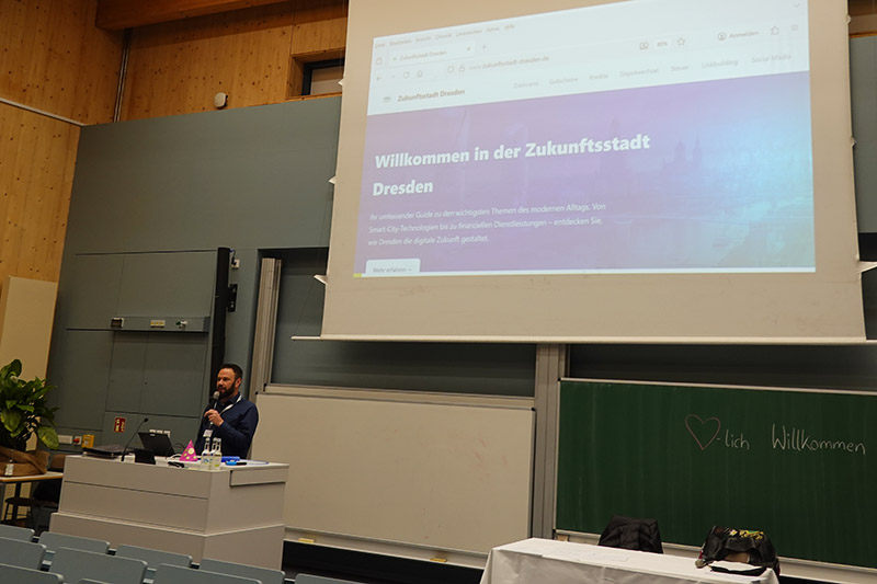 Mann hält Vortrag zur „Zukunftsstadt Dresden“ in einem Hörsaal.
