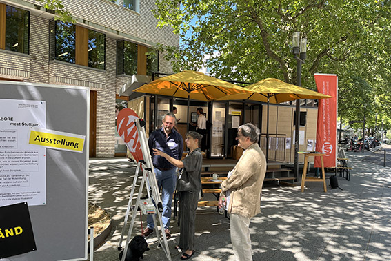 Eine Ausstellung vom KAT im Freien, Personen unterhalten sich.