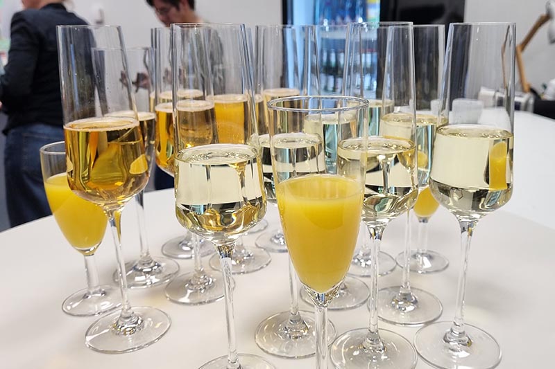 Sekt- und Orangensaftgl&auml;ser auf einem Tisch bei einer Veranstaltung.