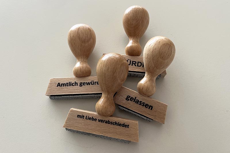 Vier Holzstempel liegen auf einem Tisch.