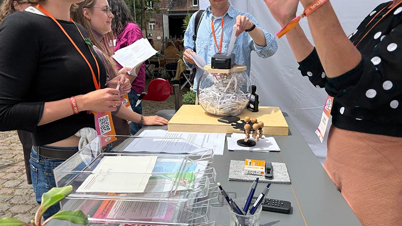Personen an einem Infostand vernichten die Loslass Dokumente.
