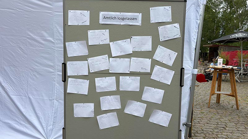 Pinnwand mit dem Titel „Amtlich losgelassen“ und zahlreichen Zettel mit den Loslass-Anliegen.