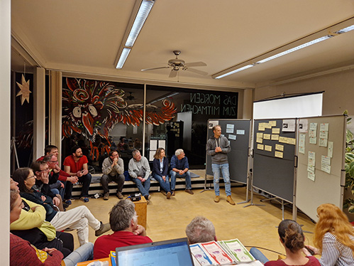 Menschen sitzen im Zukunftsraum und h&ouml;ren einem Vortrag &uuml;ber PV-Module zu.