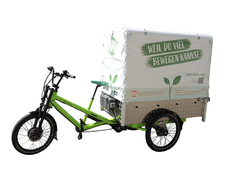 Grünes Lastenfahrrad mit Werbeplane "Weil du viel bewegen kannst" und Logos.