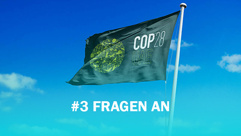 Die COP28-Fahne weht, Himmel im Hintergrund. Davor der Schriftzug: 3 Fragen an