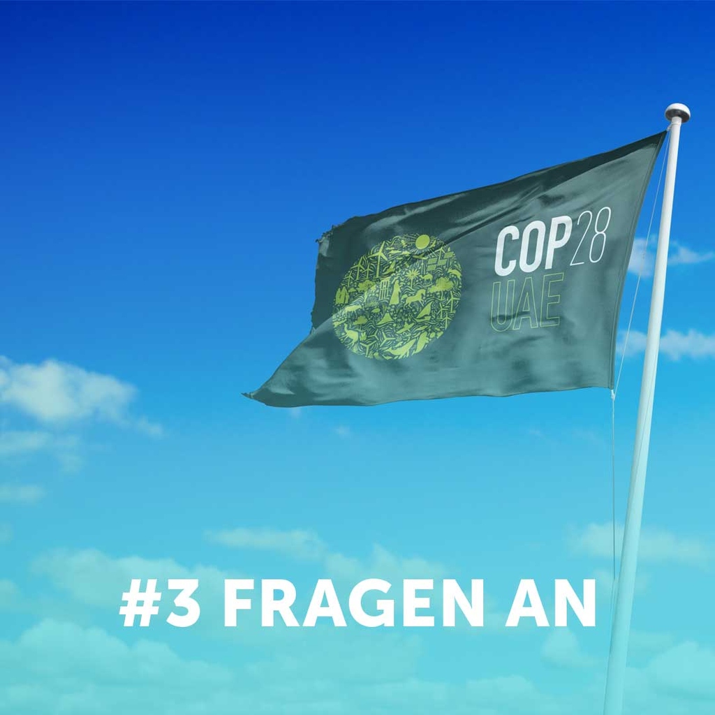 3 Fragen an. Im Hintergrund ist eine Cop28-Fahne zu sehen.